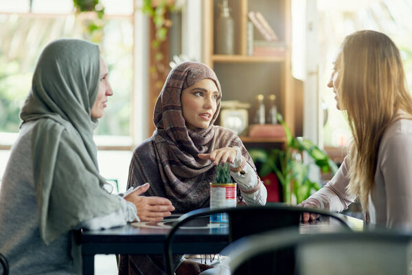 Sometimes girl talk is all the therapy you need. a group of women chatting in a cafe