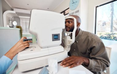 Eye test, exam or screening with a young man at the optometrist using an automated refractor. Patient testing his vision and eyesight with an optician for prescription glasses or contact lenses. clipart