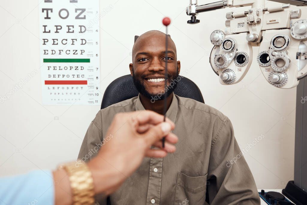 Black man having his eyes tested at an optometrist. Smiling African American male consulting with an opthamologist, having a vision and eye care checkup. Guy testing for glaucoma or myopia.