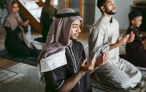 Молодая Мусульманская Семья Молится Вместе Сидит Коленях Дома Исповедует Ислам — стоковое фото