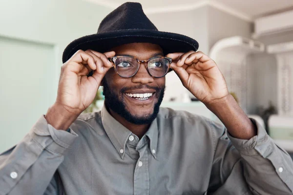 Trendy, smiling man wearing glasses, buying new eyewear and shopping for new frames at optometrist checkup. Face of a cheerful, cool and stylish male fitting frames at an optician office.