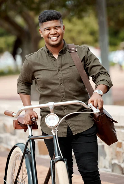 Happy business man riding a bicycle, commuting and staying active while traveling in city. Portrait of a smiling, cheerful and positive guy cycling on a bike and being carbon neutral at a park.