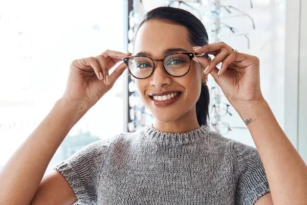 Glasses, vision and treatment by satisfied woman at optometrist, smiling and confident. Portrait of carefree female buying trendy spectacles to help with blurry vision, excited about her eyeglasses.