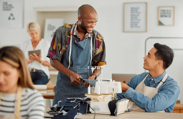 Fashion designers, colleagues and men sewing clothes in a workshop. Happy, diverse and smiling young creatives planning garment designs in a textile, clothing and manufacturing studio or factory.