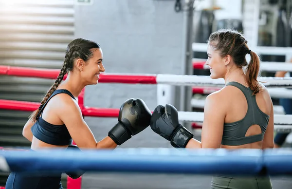 Boxing women, healthy and athletic sparring indoors. Beautiful sporty girls keep active with friendly competition through fitness and exercise. Happy fist bump in the sports center