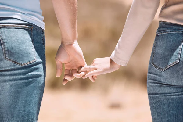 Affectionate couple holding hands showing love, caring and bonding outside together in nature. Loving boyfriend and girlfriend expressing unity, understanding and trust in their relationship.