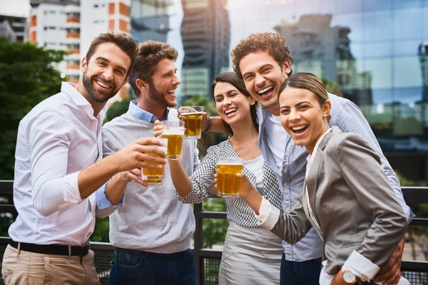 Hard workers deserve a break. businesspeople having drinks on their office balcony