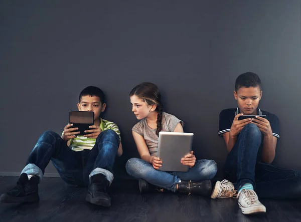 Tweens Screens Studio Shot Kids Sitting Floor Using Wireless Technology —  Fotos de Stock