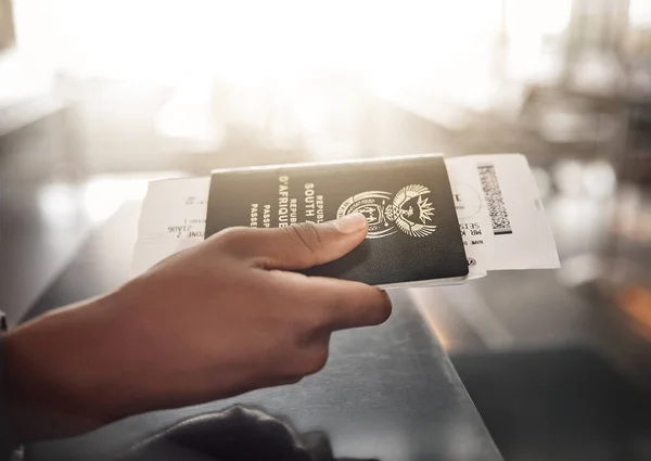 Hes almost on his way. an unrecognizable man handing over his ID book at a boarding gate in an airport