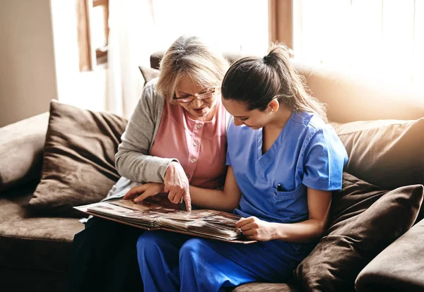 Triggering Some Old Memories Nurse Senior Woman Looking Photo Album — Fotografia de Stock