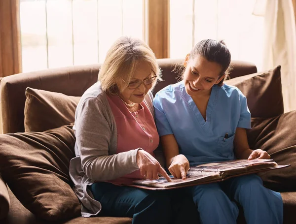 Triggering Some Old Memories Nurse Senior Woman Looking Photo Album — Fotografia de Stock