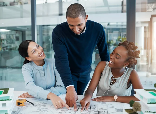 Blueprints, building engineers and architects pointing, showing and smiling in meeting to plan renovation or remodel. Diverse group of designers agreeing and choosing structure design or vision ideas.