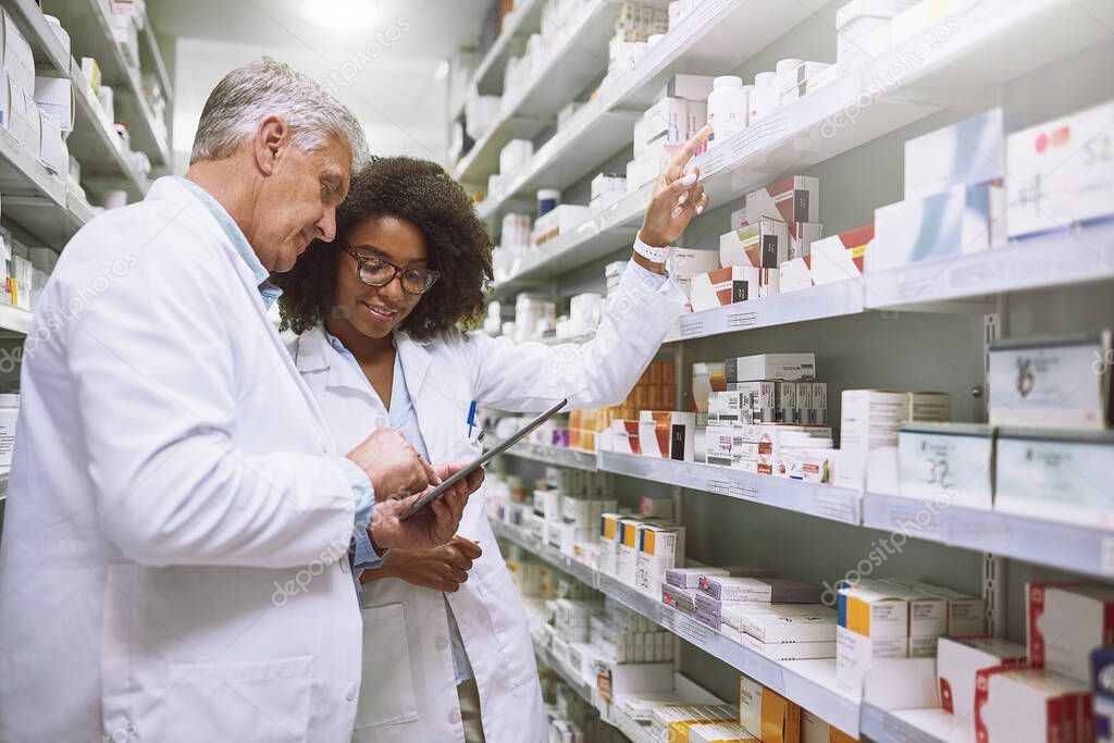 There seems to be enough of this. two focused pharmacist walking around and doing stock inside of a pharmacy
