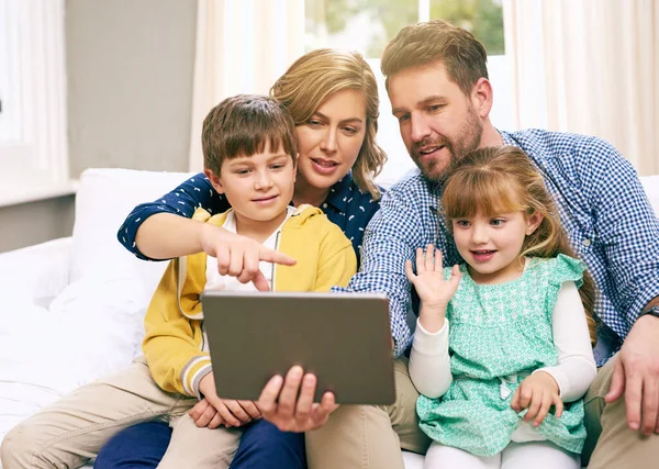 Learning new apps together as a family. a family using a tablet together at home