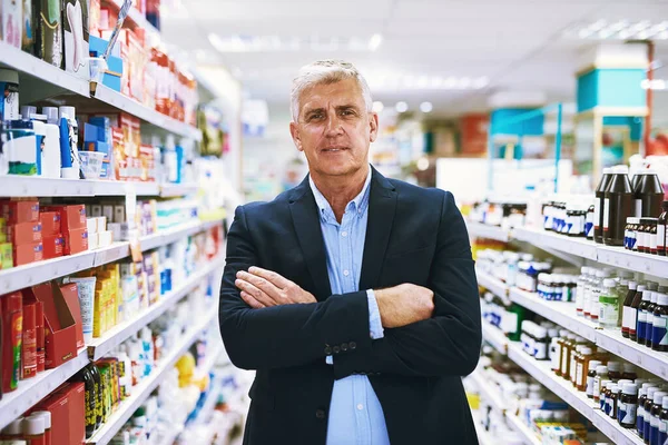 They have everything you need to get better. Portrait of a confident well dressed mature man standing in a pharmacy with arms folded while looking at the camera