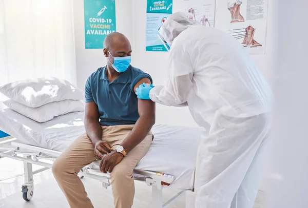 Patient getting covid vaccine, injection and cure from a doctor in a clinic. Man with plaster bandage on arm after flu jab, antiviral shot and health treatment to boost immunity and prevent illness.