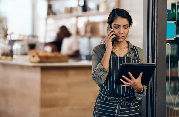 Female Cafe Business Owner Using Phone Talking Ordering Reading Tablet — 스톡 사진