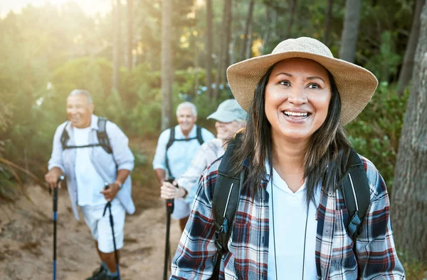 . Hiking, adventure and exploring with a senior woman and her retired friends on a hike outdoors in nature. Enjoying a walk or journey of discover in the forest or woods for leisure and recreation