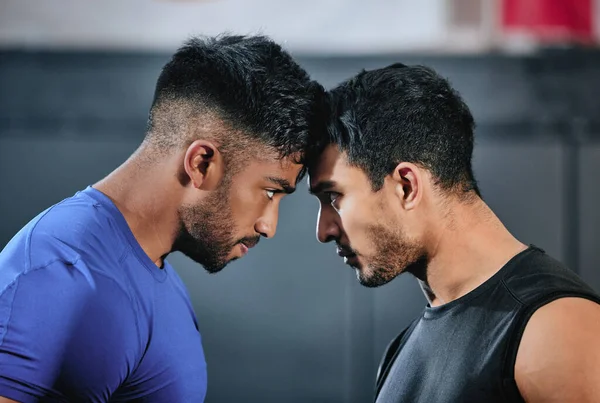 Healthy, serious and fit male athletes staring, facing and looking ready before a fight. Strong young men in an active challenge, a battle of power against strength and a motivation for winning