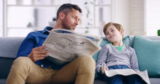 Father Son Bonding Reading Newspaper Relaxing Sofa Home Happy Parent — Vídeo de Stock