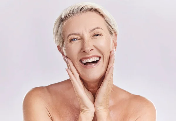 Botox, menopause and anti aging woman in beauty, skincare or face wash portrait in a studio. Plastic surgery, dermatology or cosmetics senior model with a smile touching her natural looking skin.
