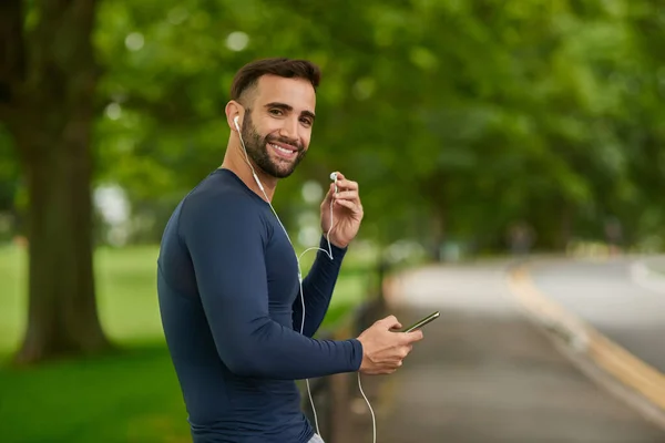 Its the music that keeps me going. Cropped portrait of a handsome young male runner checking his messages during his workout