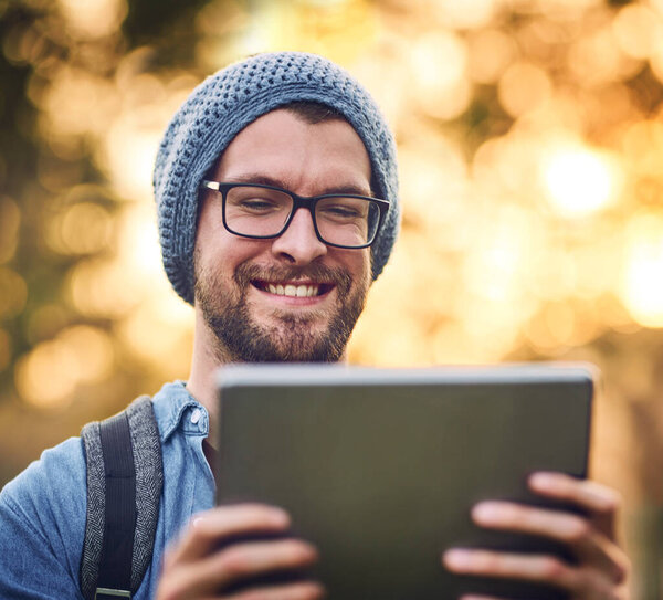 Connectivity even in the outdoors. a handsome young man using a tablet outdoors