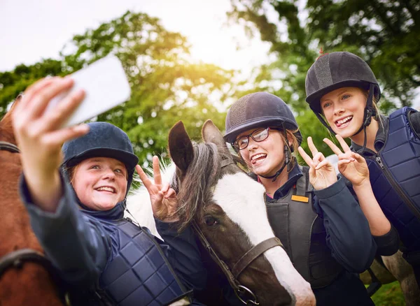 Horse riding friends make the best kind of friends. a group of young friends taking a selfie while going horseback riding