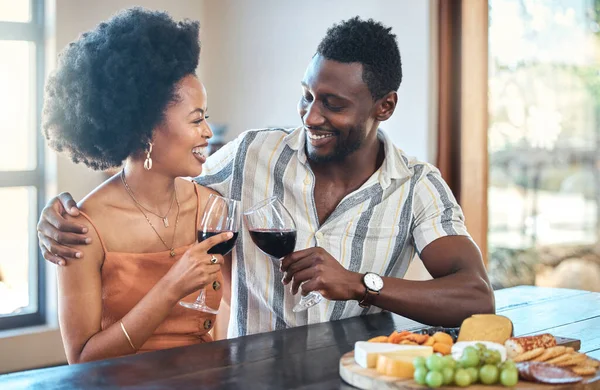 Young couple celebrating with wine and cheers at resort, laugh and bonding on romantic date. Carefree, in love black girlfriend and boyfriend toasting, enjoying relationship, alcohol and conversation.