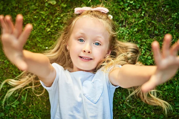 Pick Portrait Cheerful Little Girl Lying Grass Stretching Her Arms — Stok fotoğraf