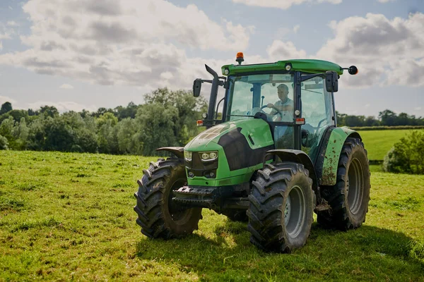 Every farm needs a tractor. Full length shot of a green tractor on an open piece of farmland