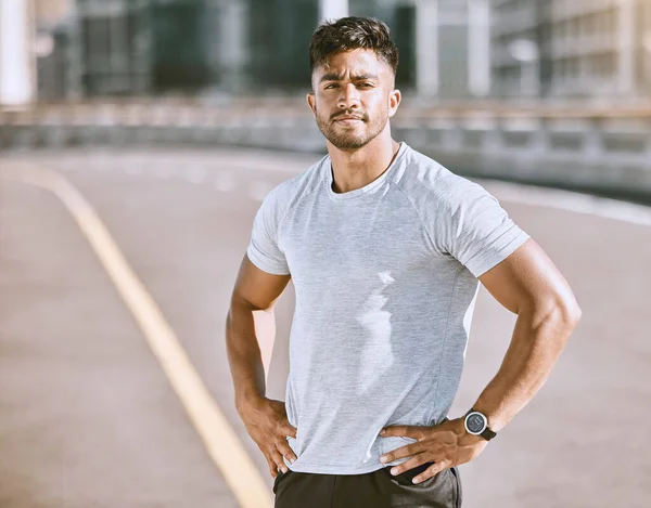 Fitness, sports and runner with motivation, wellness goals and vision in city, town or dowtown. Portrait of active, athletic or healthy man on street for routine running workout, exercise or training.