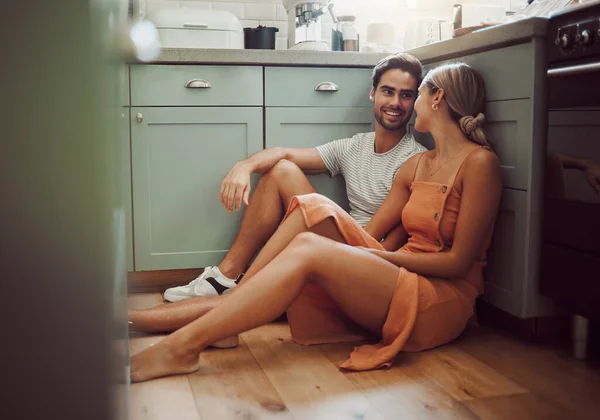 Couple, in love and on kitchen floor looking into their eyes on luxury real estate. Man, woman and communication and a conversation in a new home, house or room before breakfast with family