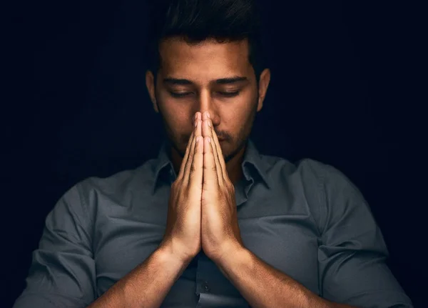 Give us this day our daily bread. Closeup shot of a young man praying with his eyes closed