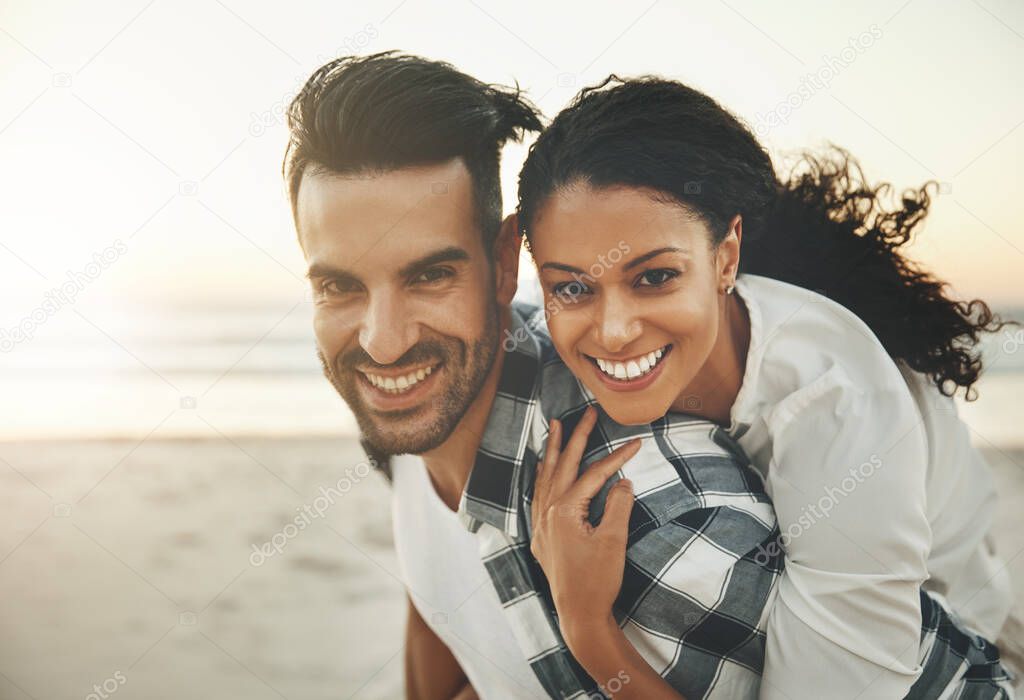 As long as we have each other, we have everything. a young man piggybacking his girlfriend while spending the day at the beach