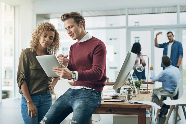 Creating a cool marketing campaign with one smart app. two young colleagues using a digital tablet together in a modern office