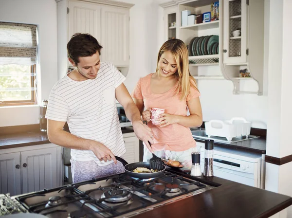 Great mornings are made with love and food. a happy young couple cooking breakfast together at home