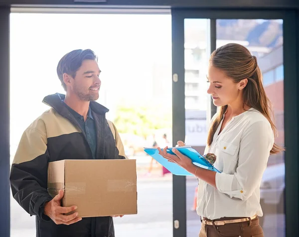 Getting your package delivered on time every time. a businesswoman signing for her delivery from the courier