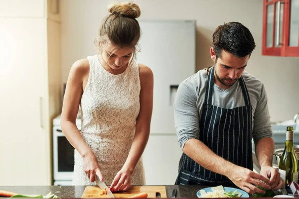 Cooking with love provides food for the soul. an affectionate young couple preparing food together at home