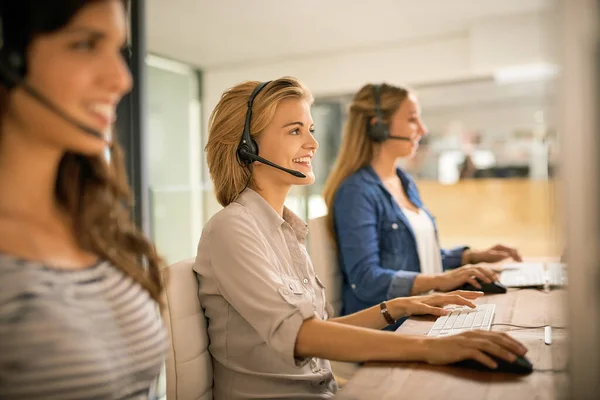 Using all their resources to solve your problems. a group of young women working in a call center