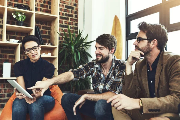 Use technology to ask questions. a group of designers using a tablet in their brainstorming session