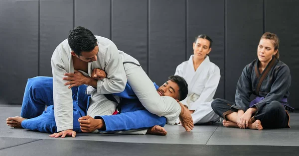 Fight, karate class and martial arts teamwork in competition, challenge or self defense sport in wellness school. Fitness sports coach teaching students gym workout, floor exercise or health training.
