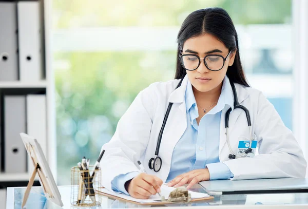 Doctor, insurance and medical of a woman filling out patient history for diagnosis at the hospital. Healthcare worker or nurse writing on paper with clipboard for health and wellness at the office