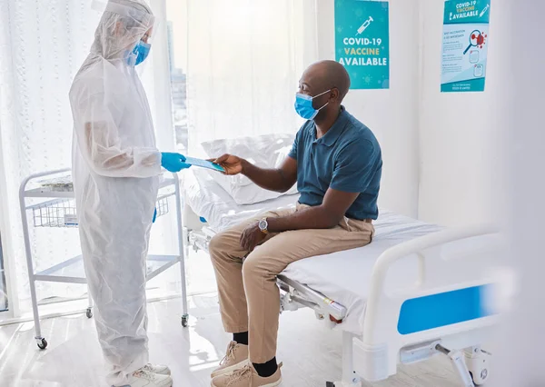 Black man talking to doctor, with covid mask and getting medical wellness advice at hospital or clinic. Expert, professional or healthcare worker helping patient, doing checkup and giving brochure.