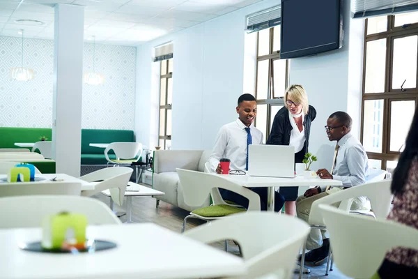 Getting together to strategise better. a group of businesspeople working together on a laptop in an office