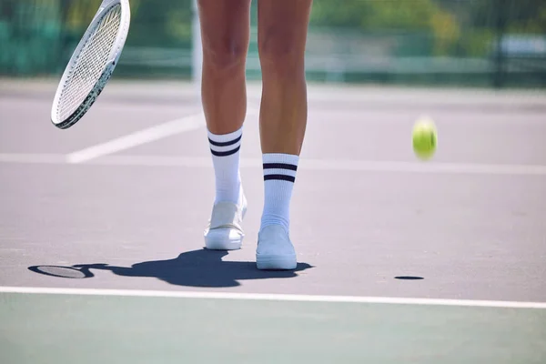 Fitness, tennis and sports legs of woman with racket and ball walking on court after serving in training, workout or exercise. Sporty shoes, active or healthy player losing match, game or competition.