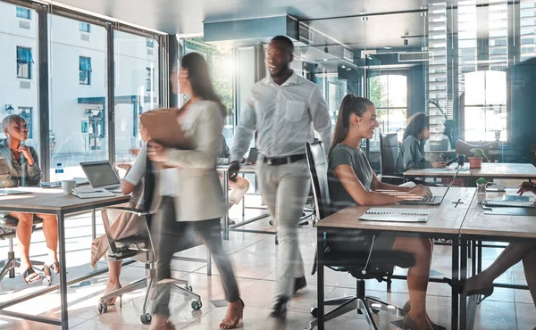 Busy office with a productive team of employees working hard and fast to complete tasks and projects. Colleagues, coworkers or business people in a modern workplace being creative.