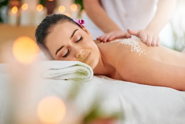 Invigorate your senses with a spa day. an attractive young woman getting an exfoliating treatment at the spa