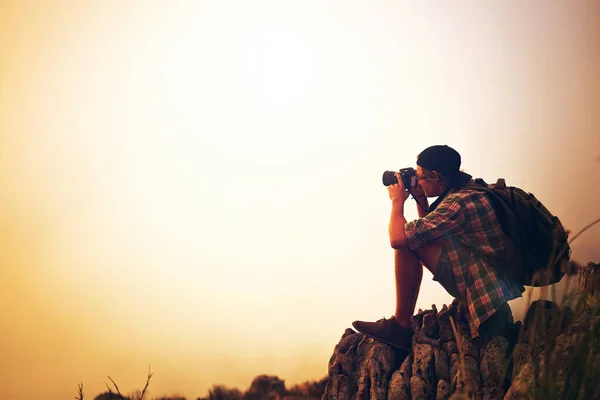 Theres no fogging his focus. a young photographer taking a picture of a foggy landscape from the top of a mountain