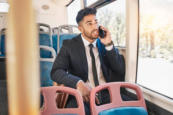 Businessman consulting on a phone call on a bus in the morning travel to work in the city. Entrepreneur, employee and worker speaking to a contact on a mobile cellphone in public transportation.